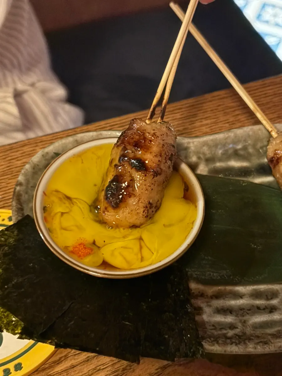 Tsukune served with egg yolk and seaweed