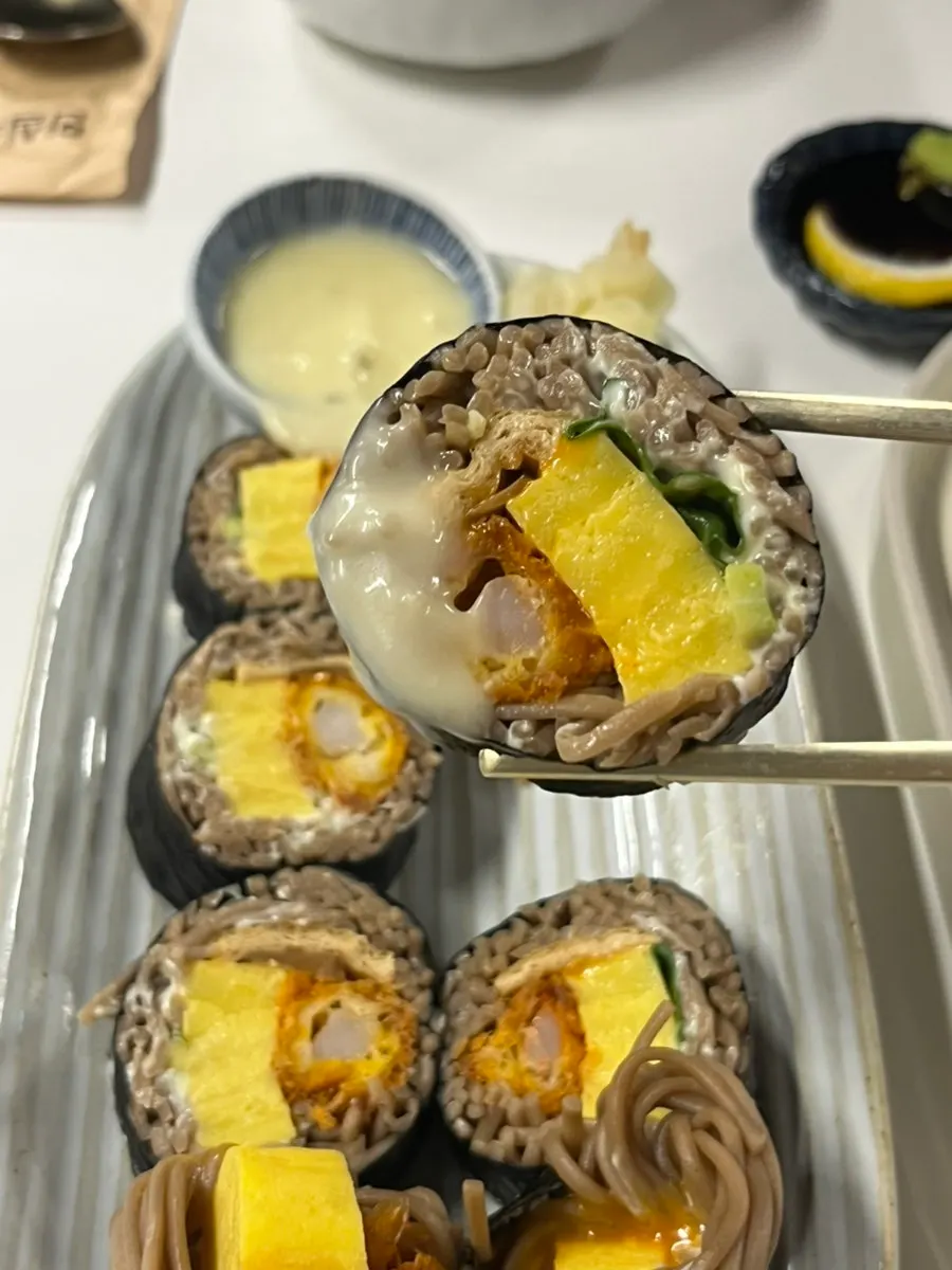 Cross-section of buckwheat gimbap with fried shrimp inside