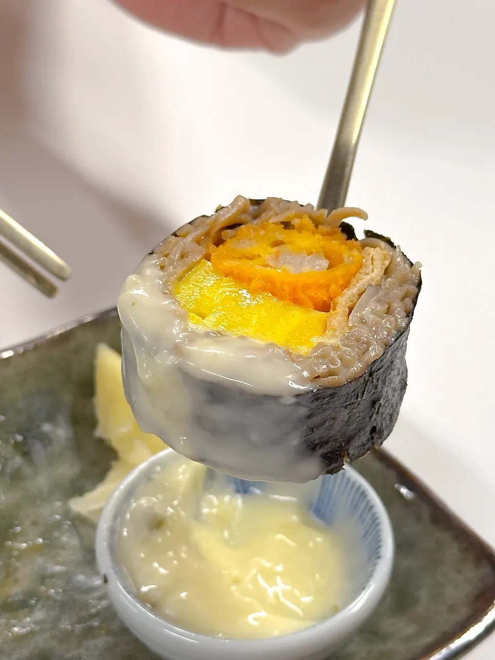 A piece of shrimp buckwheat gimbap dipped in tartar sauce