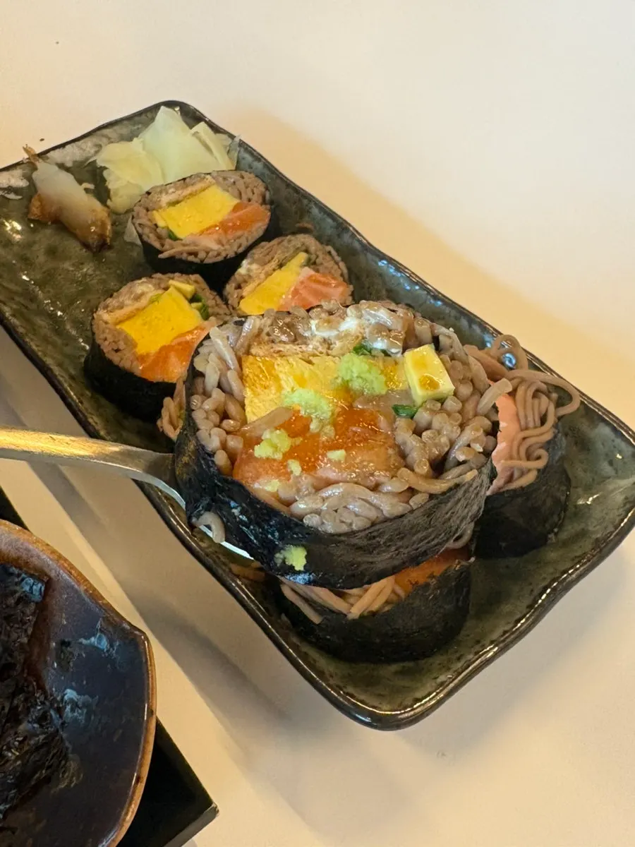 A piece of buckwheat gimbap with soy sauce and wasabi