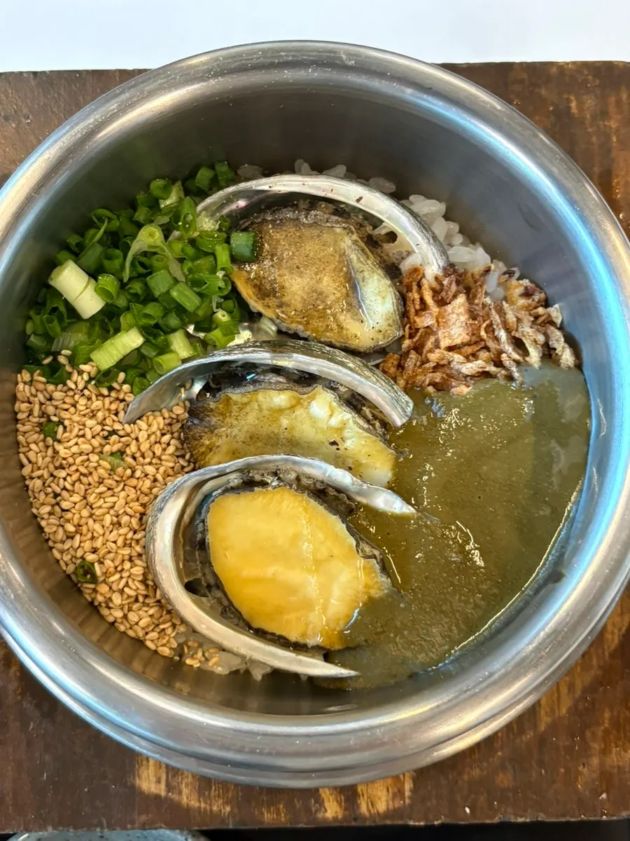 Close-up of pot rice topped with abalone and butter