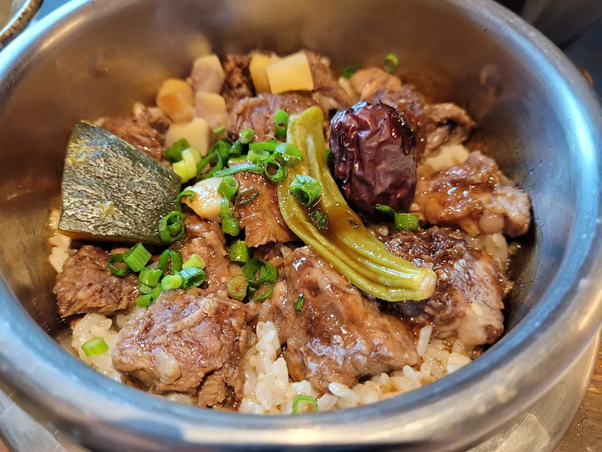 A table setting with beef rib pot rice and abalone butter pot rice