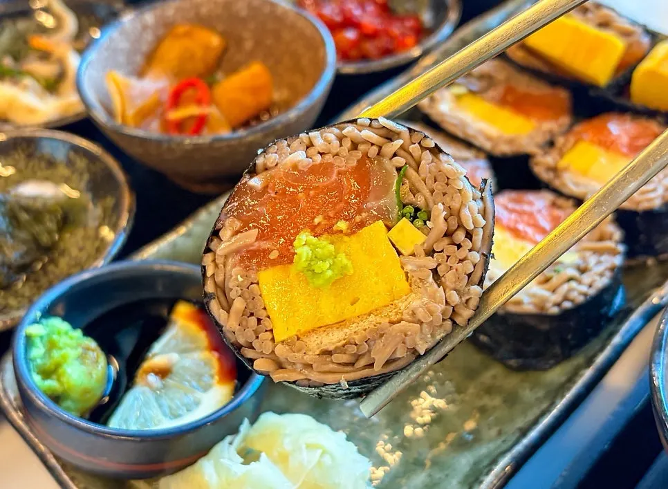 Cross-section of raw salmon buckwheat gimbap with noodles and egg