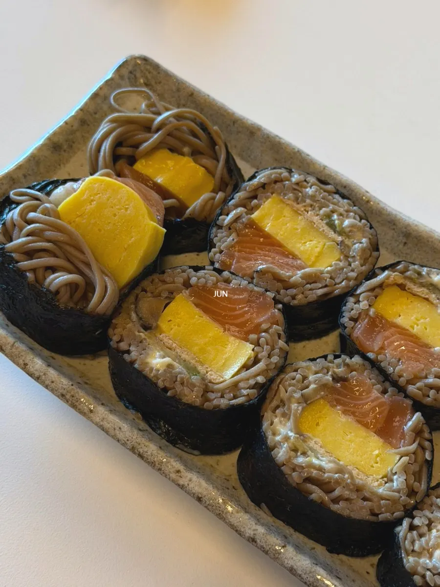 Raw salmon buckwheat gimbap dipped in soy sauce