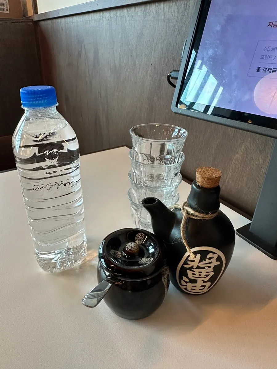 Basic table setting with water, water cups, soy sauce, and sesame seeds