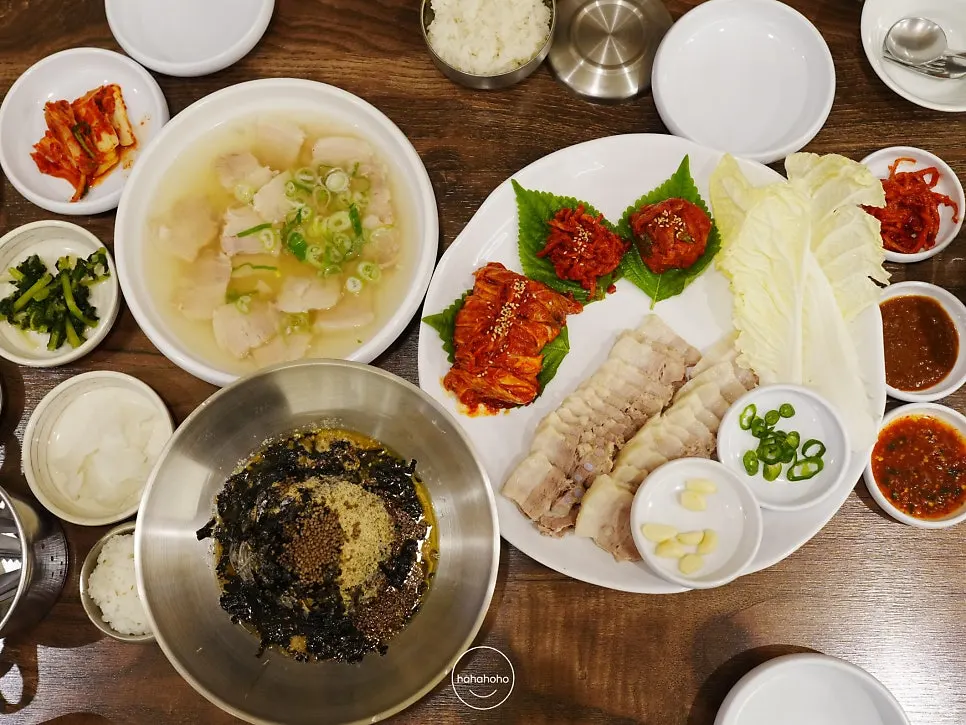 Table spread with daegabossam, suyuk gukbap, and perilla-oil Hamhung noodles