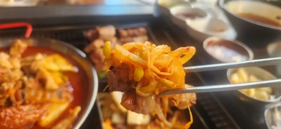 불판 위에서 구워지는 묵은지와 콩나물