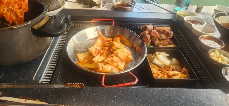 고기와 곁들임이 함께 놓인 불판
