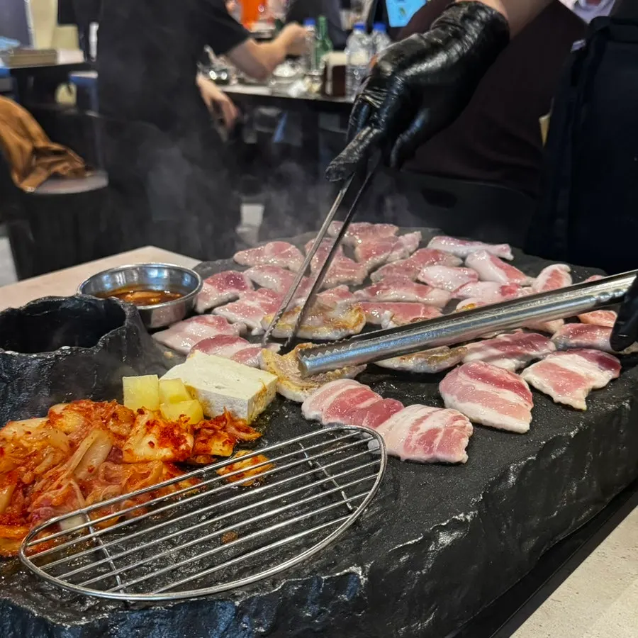 Server grilling the meat directly for guests