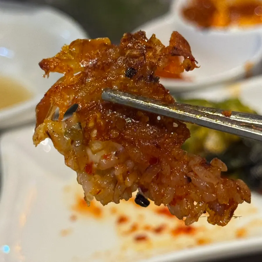 Scraping up the crispy fried rice stuck to the stone grill