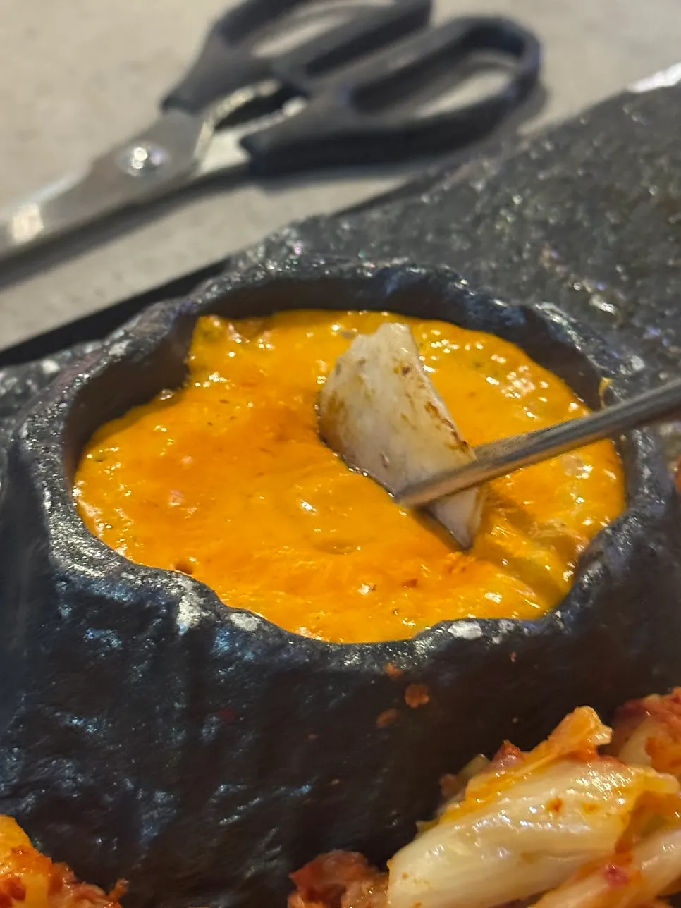 Panceta de cerdo mojada en el fondue de queso lava