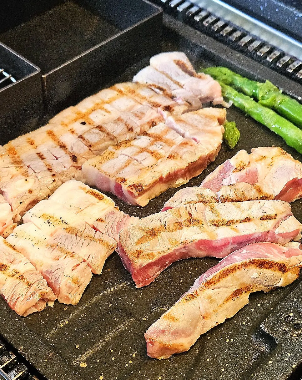 Staff grilling meat on the tabletop grill