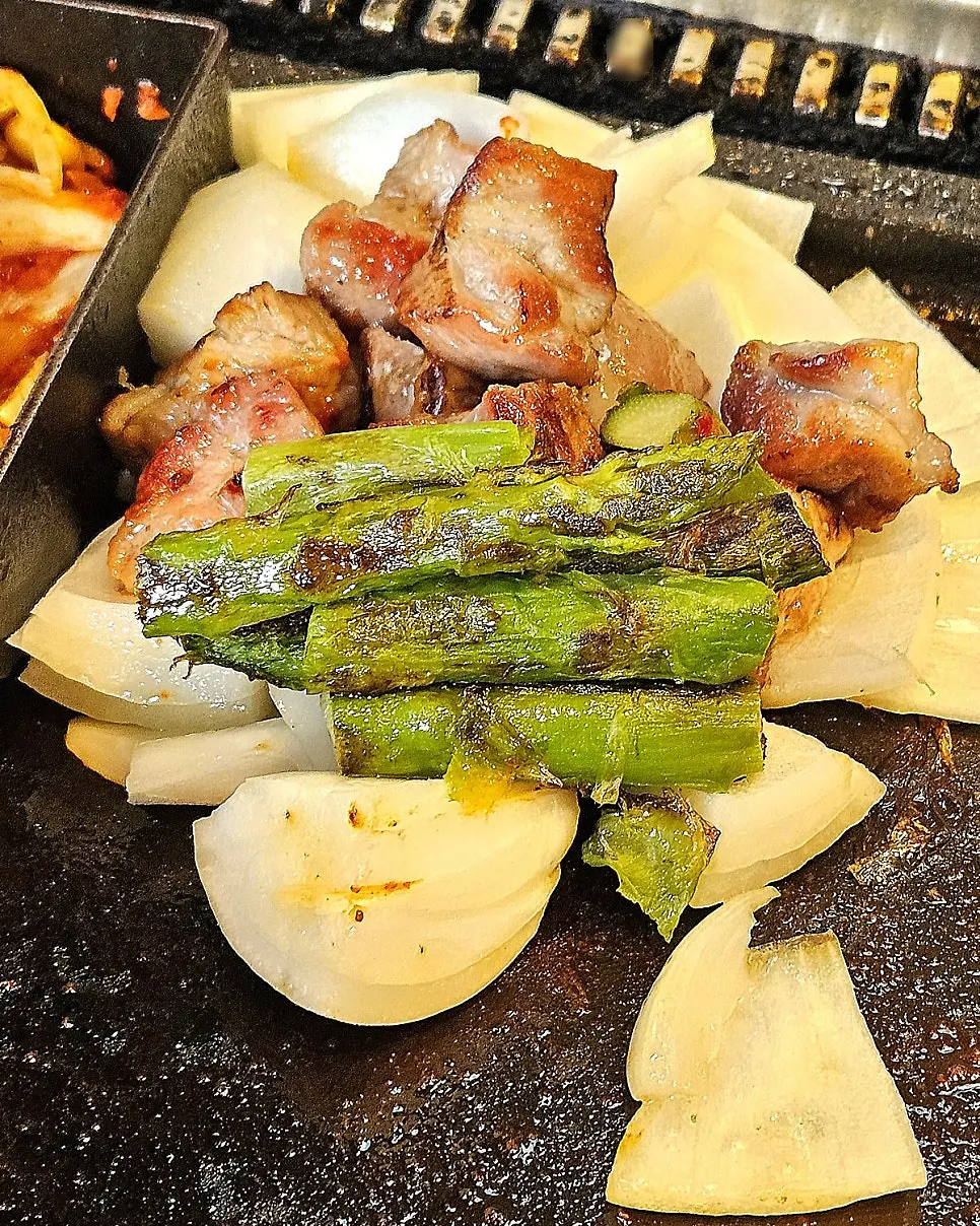 Grilled asparagus with a plate of meat