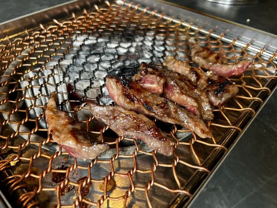 Wine-marinated short rib caramelizing over charcoal