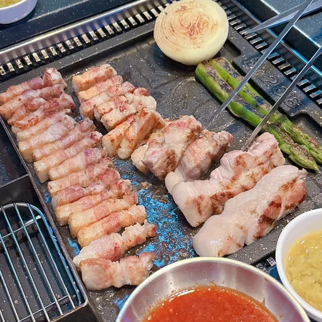 Staff grilling meat on the tabletop grill