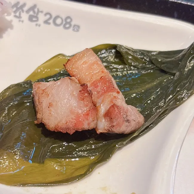 Pork belly topped with minced garlic sauce and grilled asparagus