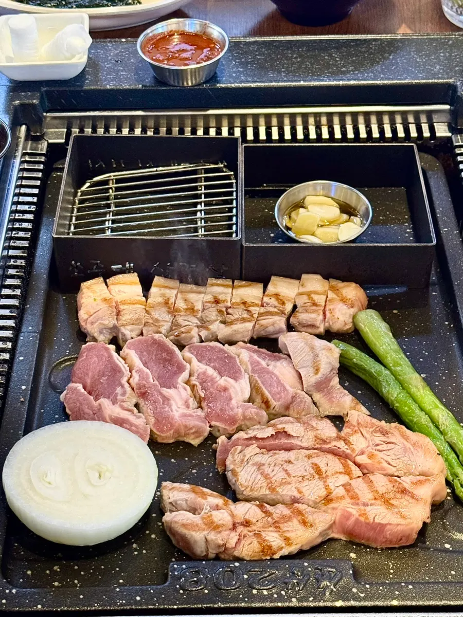 Staff member grilling meat on the tabletop grill