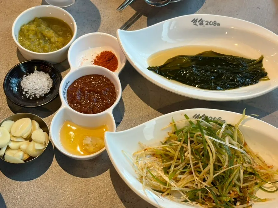 Side dish spread with shredded scallions and sauces at Ssosam 208