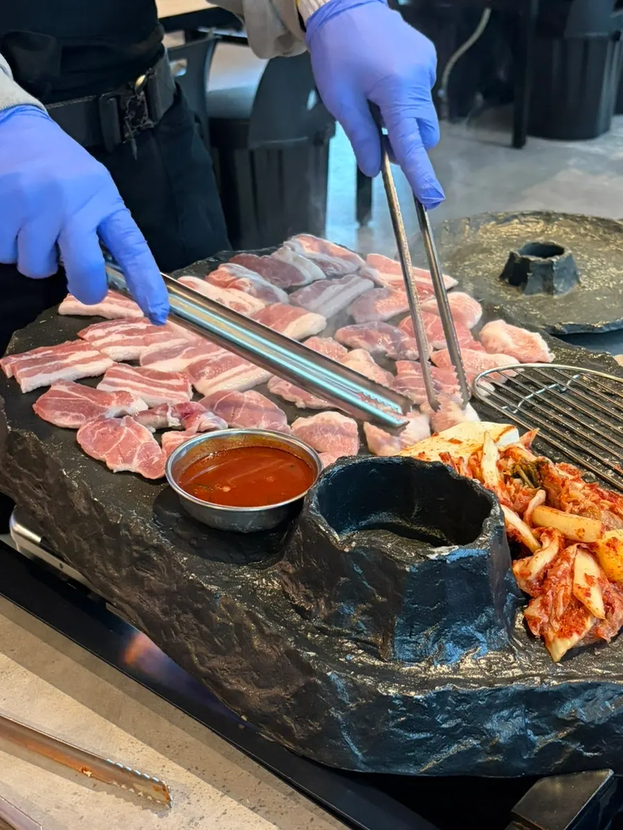 Pork belly grilling on the stone plate at Ssosam 208