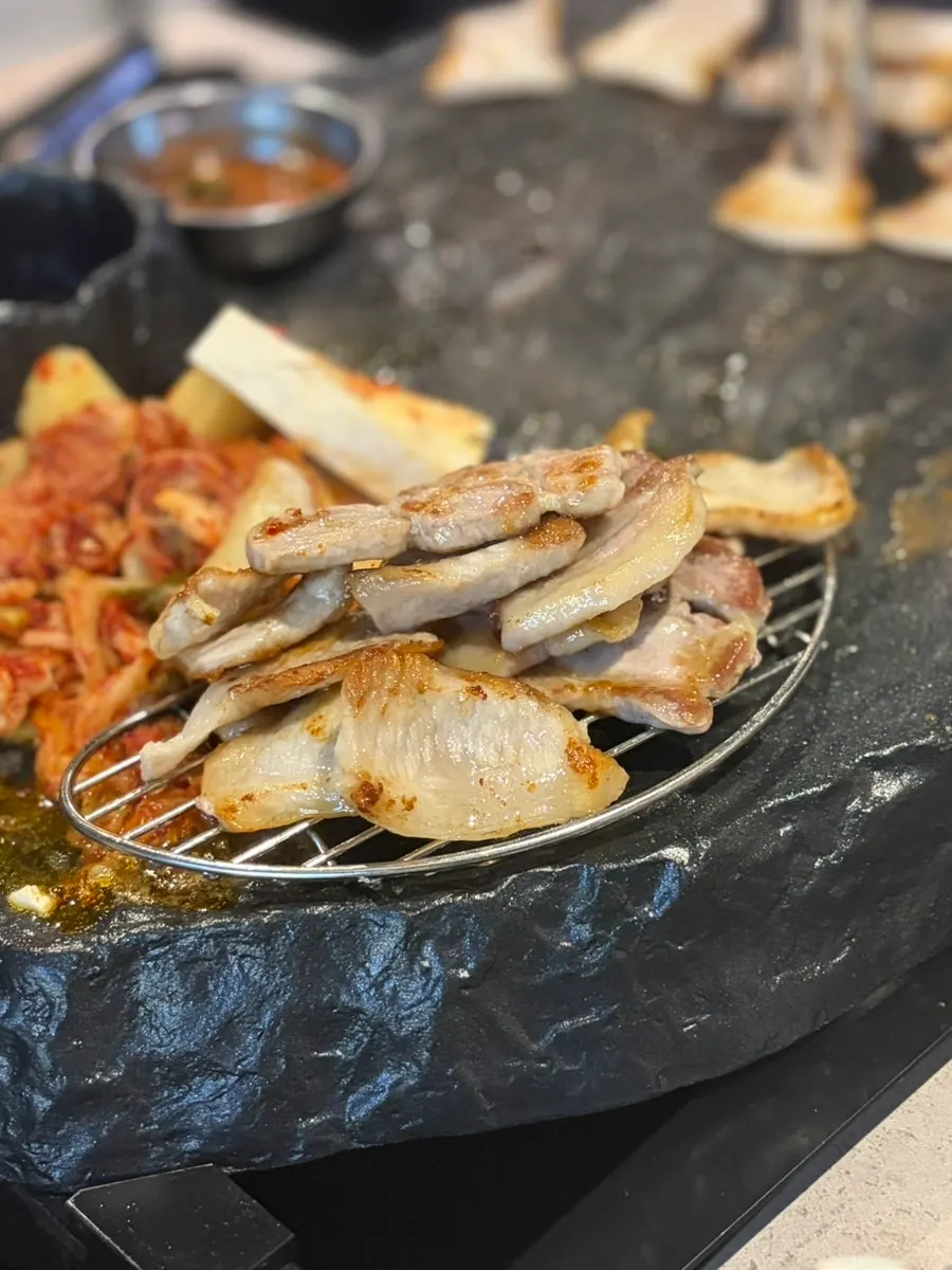 노릇하게 구워진 얇은 돌판 삼겹살