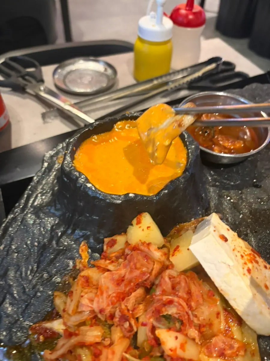 치즈 퐁듀에 찍은 삼겹살 한 점