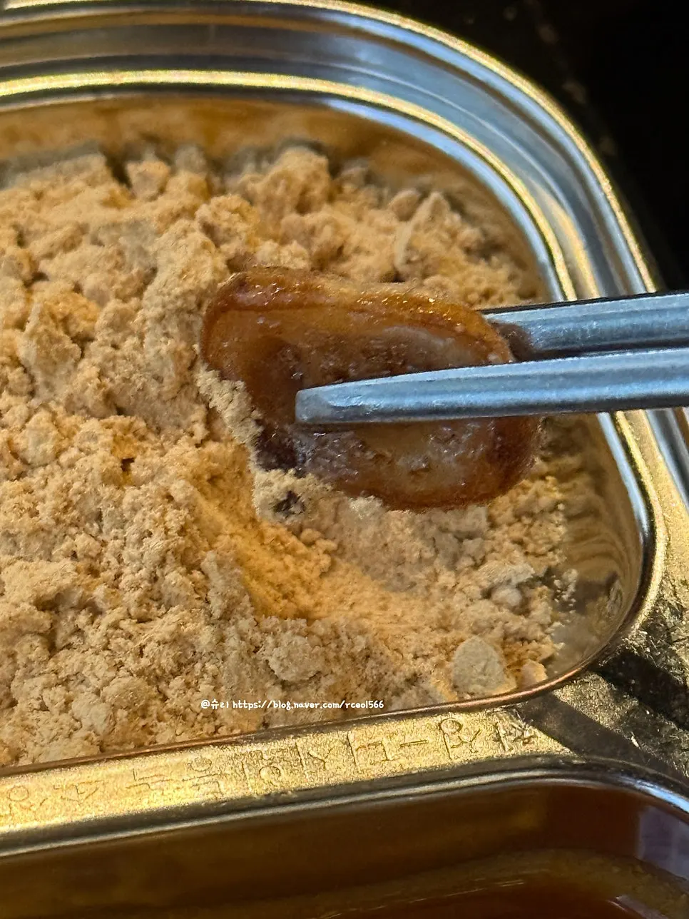 A piece of makchang coated in soybean powder