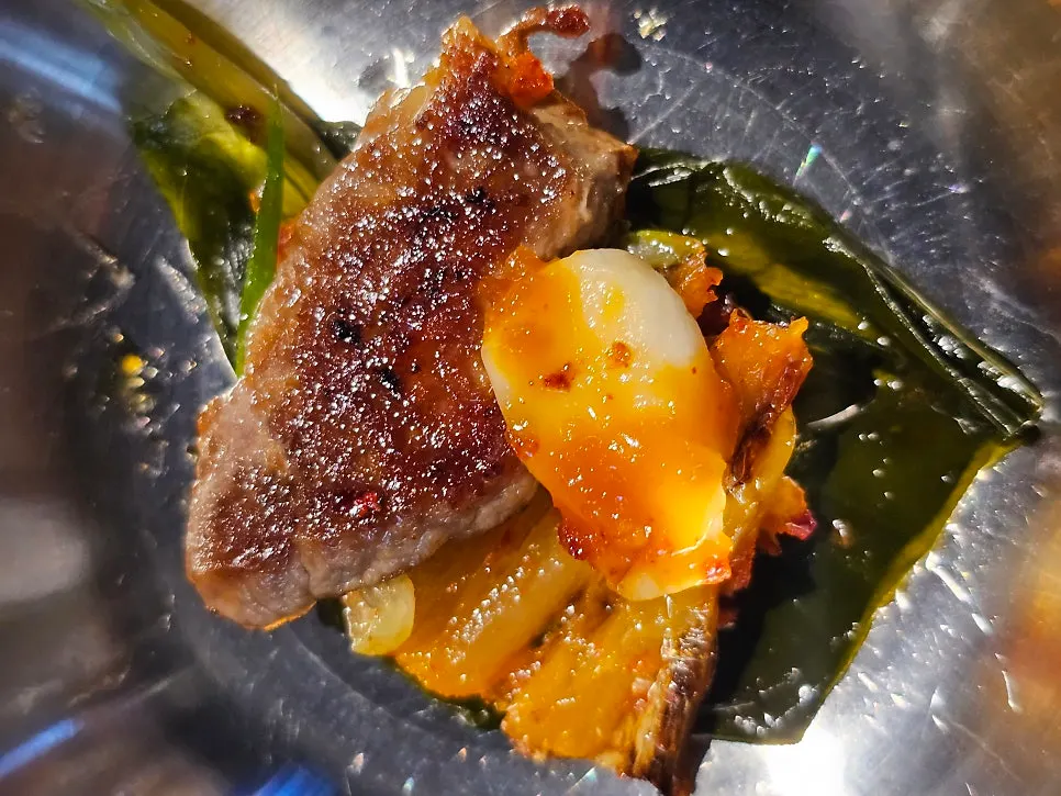 Pork neck served with myeongi-namul, grilled kimchi, and garlic