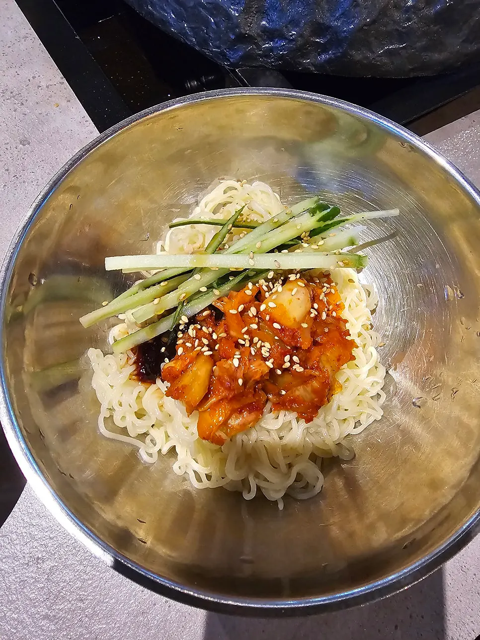 Grilled pork belly placed on top of bibimmyeon