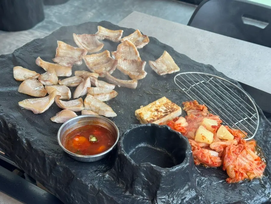 Thin pork belly cooking on the stone plate
