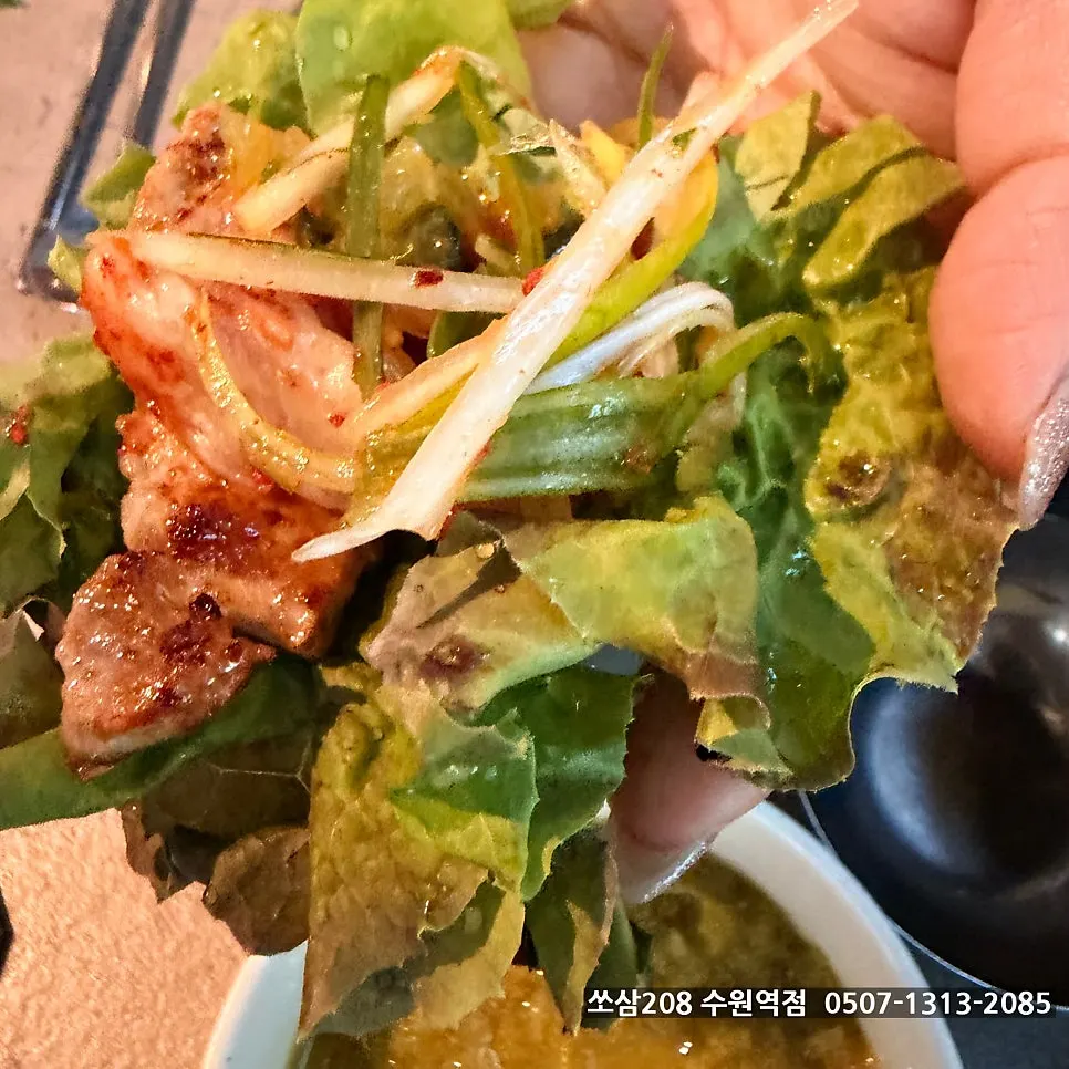 A lettuce wrap topped with meat and scallion strips