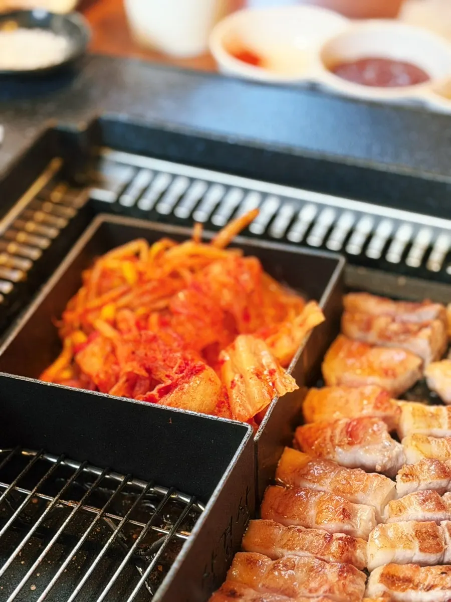불판 옆 칸에 올린 김치와 콩나물