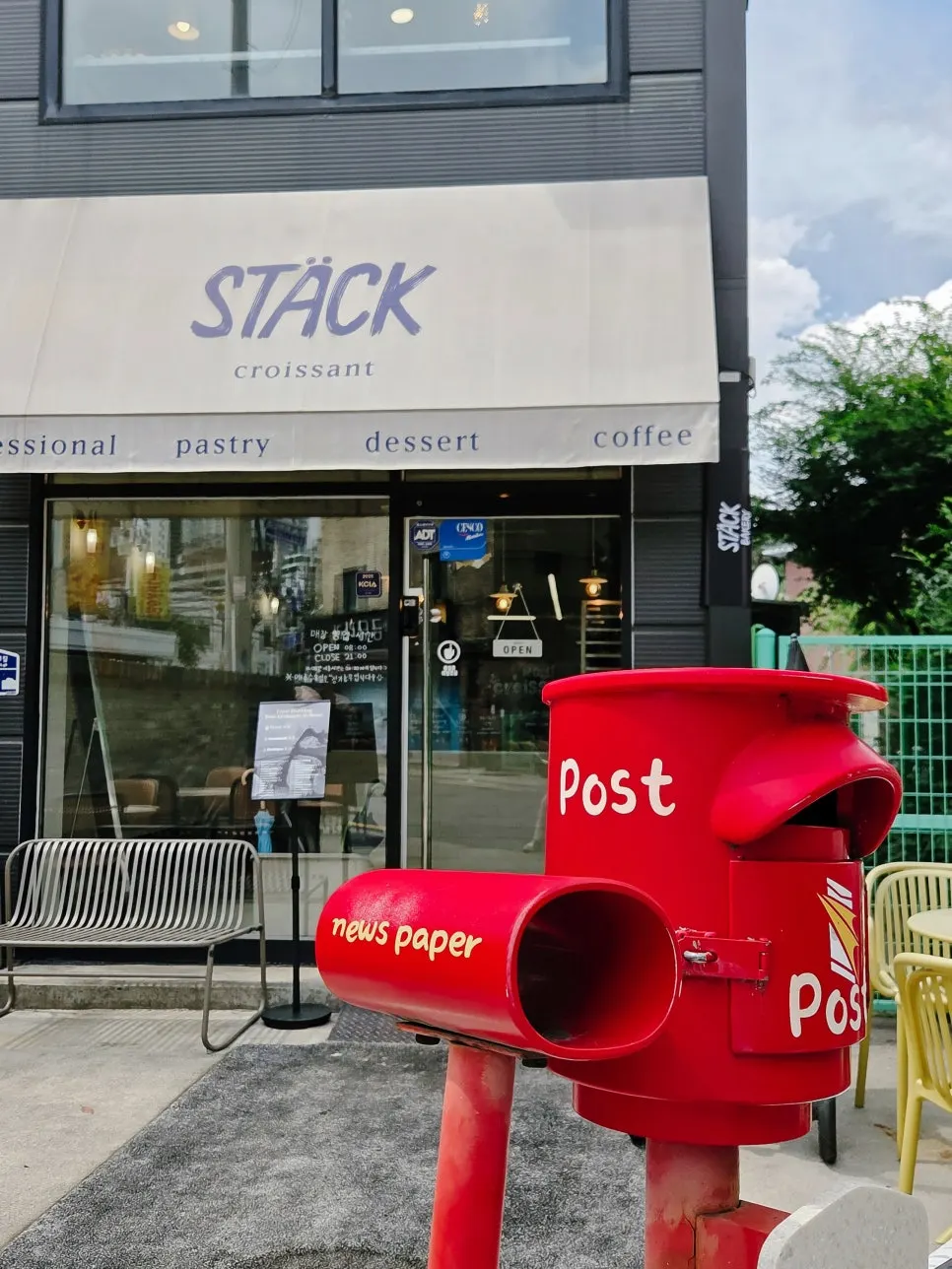 Stack Bakery building with 1st-floor outdoor tables and 2nd-floor floor-to-ceiling windows