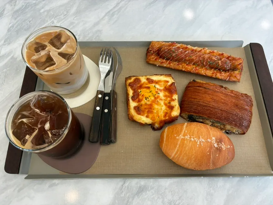 Iced americano, café latte, and bread table setting