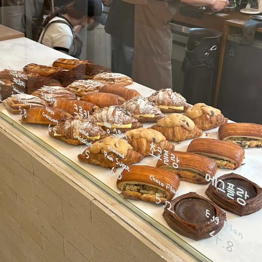Display case with croissants, kouign-amann, and other pastries