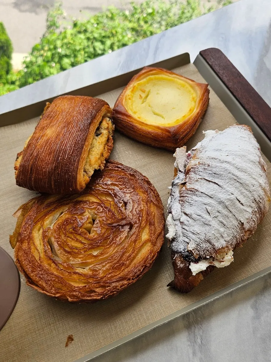 Plate of bread and iced caffe latte placed at the window seat