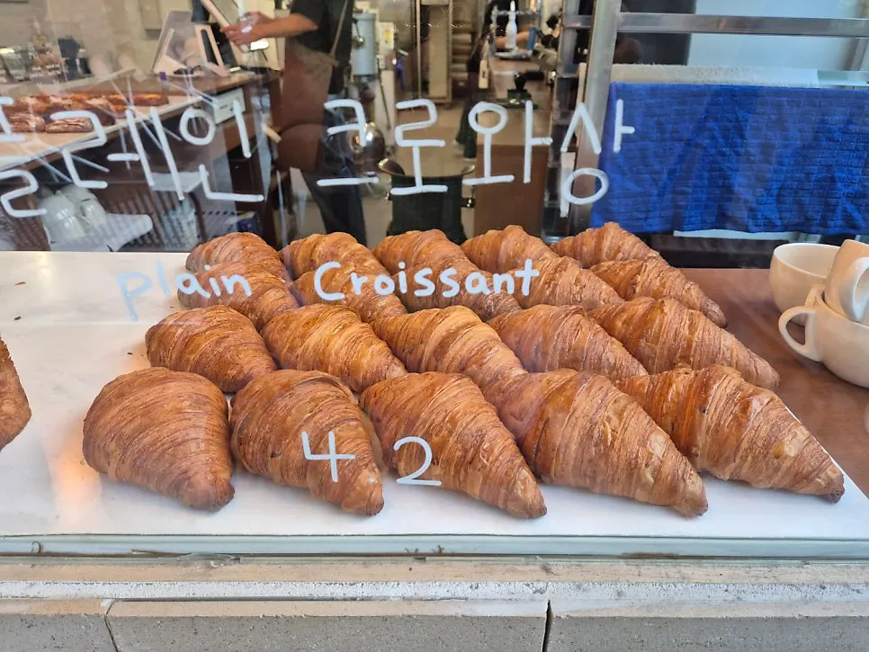 Bread display case filled with various croissants