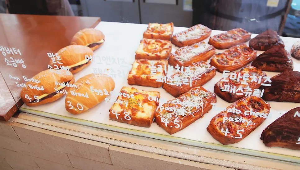 Paparan menu bakeri termasuk kouign-amann dan salt bread