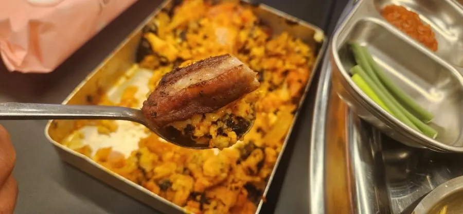 A piece of jjokgalbi wrapped in green onion kimchi