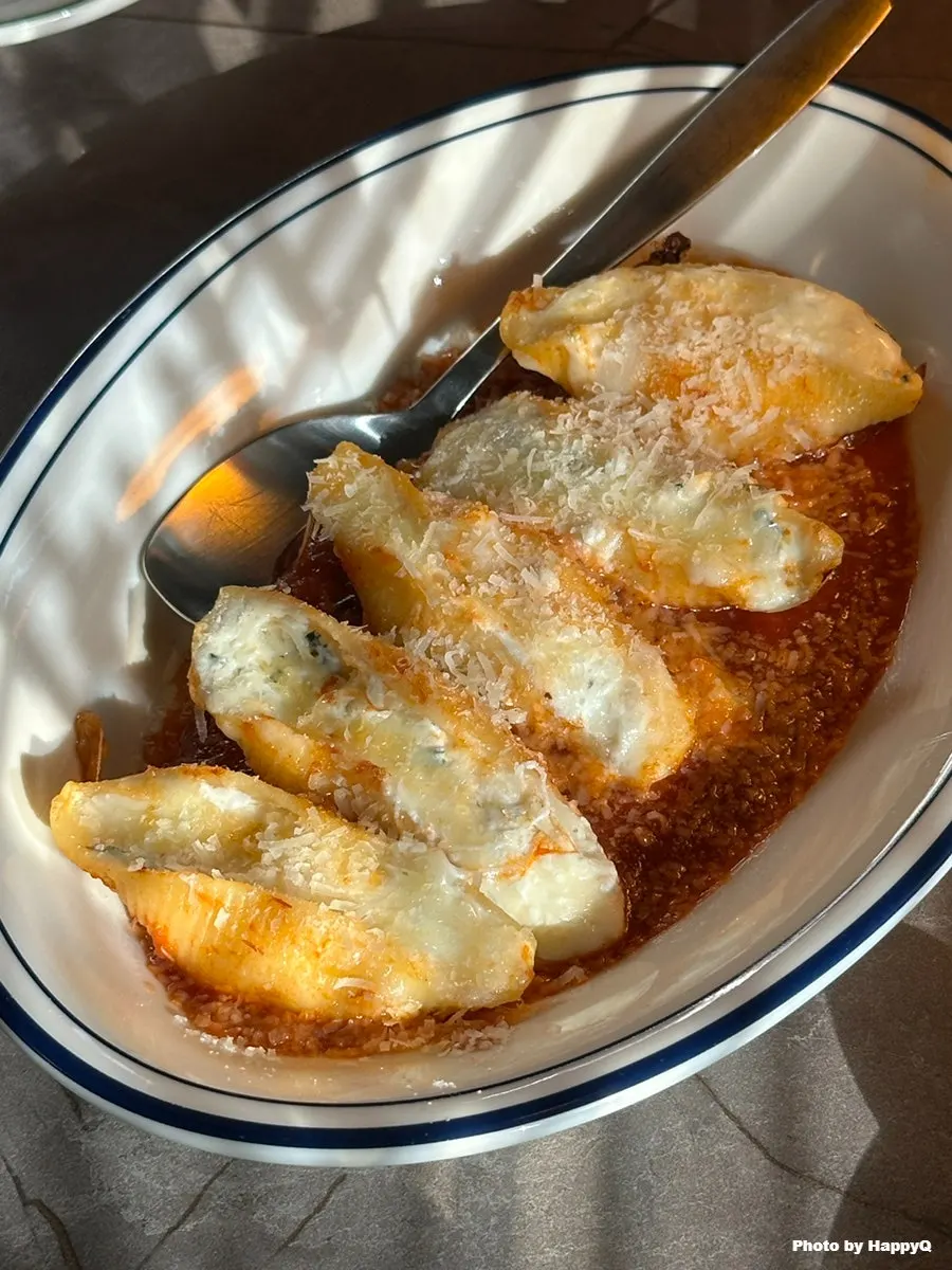 Shell pasta topped with tomato sauce and mozzarella cheese