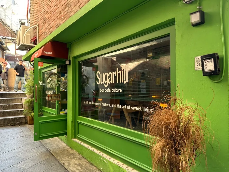 Red tables on Sugar Hill's outdoor terrace and the Sinheung Market alley