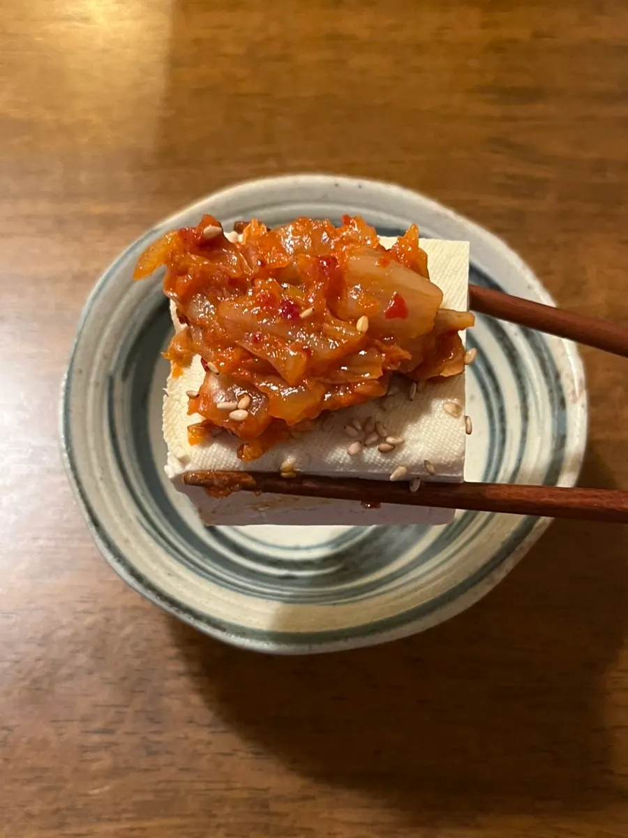 A piece of stir-fried kimchi on top of tofu