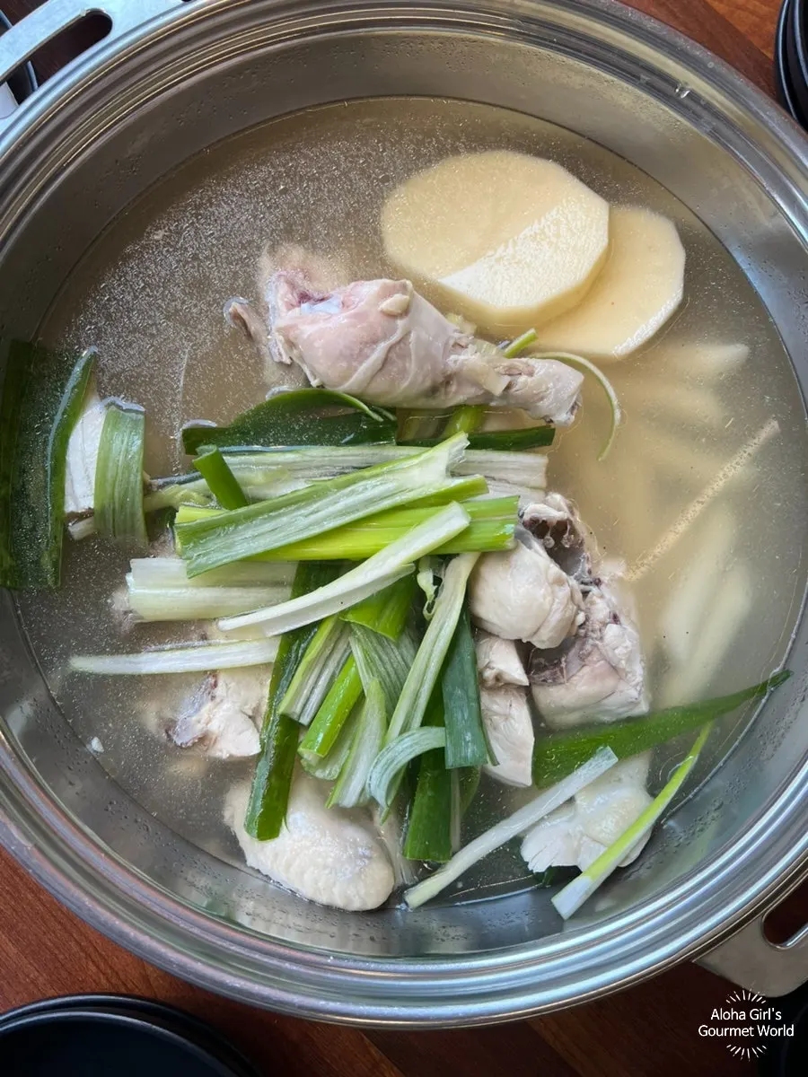 Pot of Sugyeokok dak hanmari with chicken, green onion, rice cake, and potato