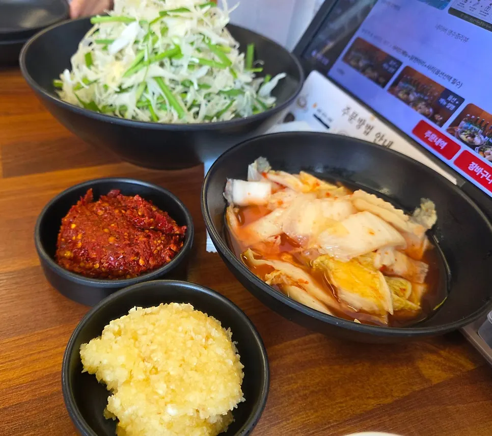 Basic table setting with dipping sauce, minced garlic, and water kimchi