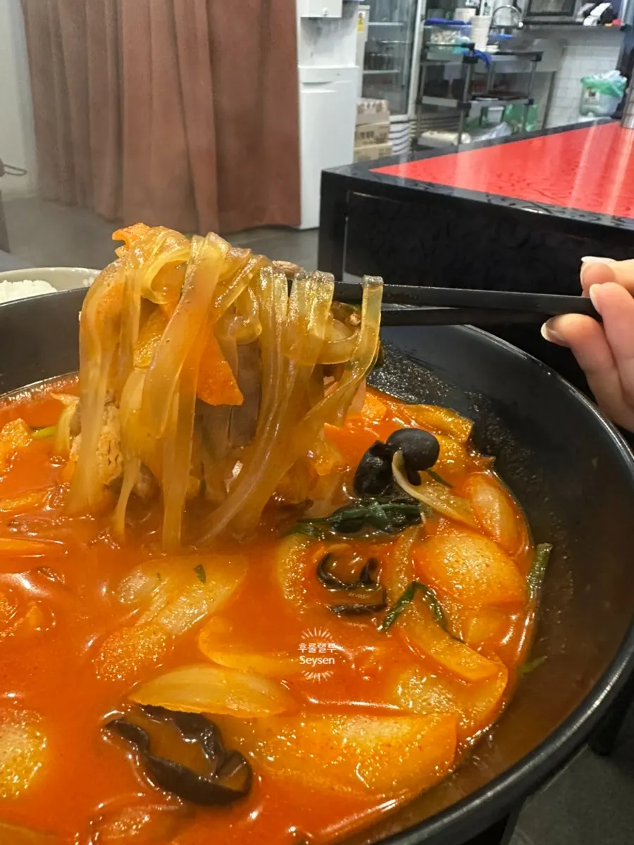 Lifting the flat glass noodles out of the jjamppong-bap