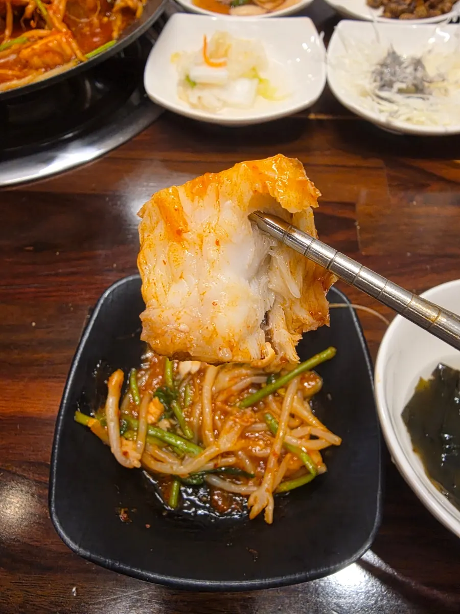 A chopstick-full of sauce-coated agu-jjim