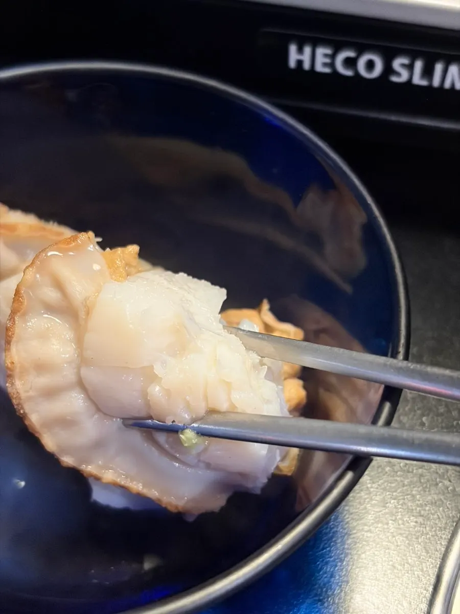 A scallop cut in half to show its plump flesh
