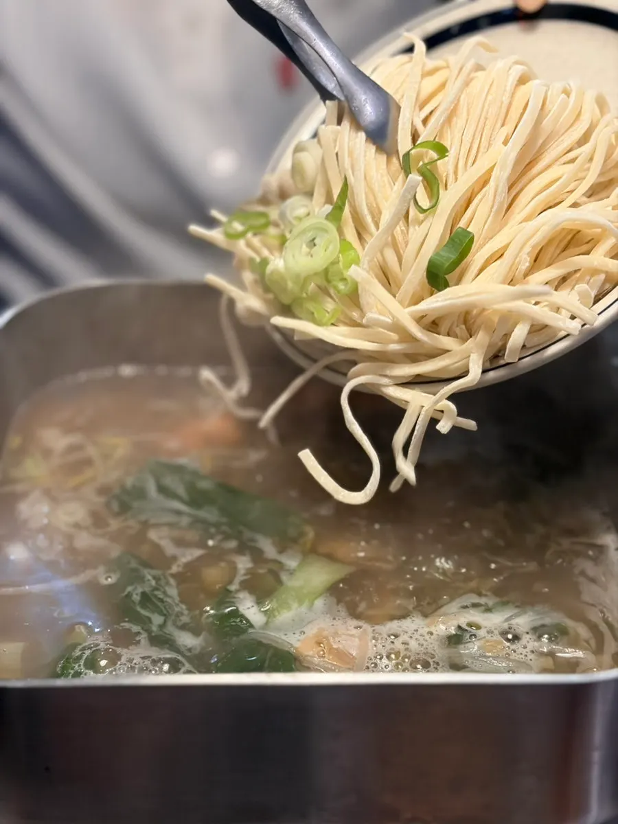 Kalguksu noodles cooking in seafood-boil broth