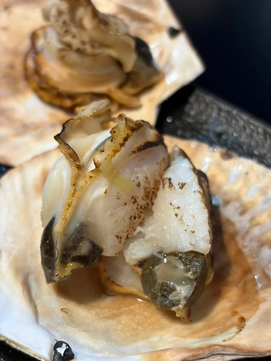 A drinking-food pairing of seafood boil and grilled scallops