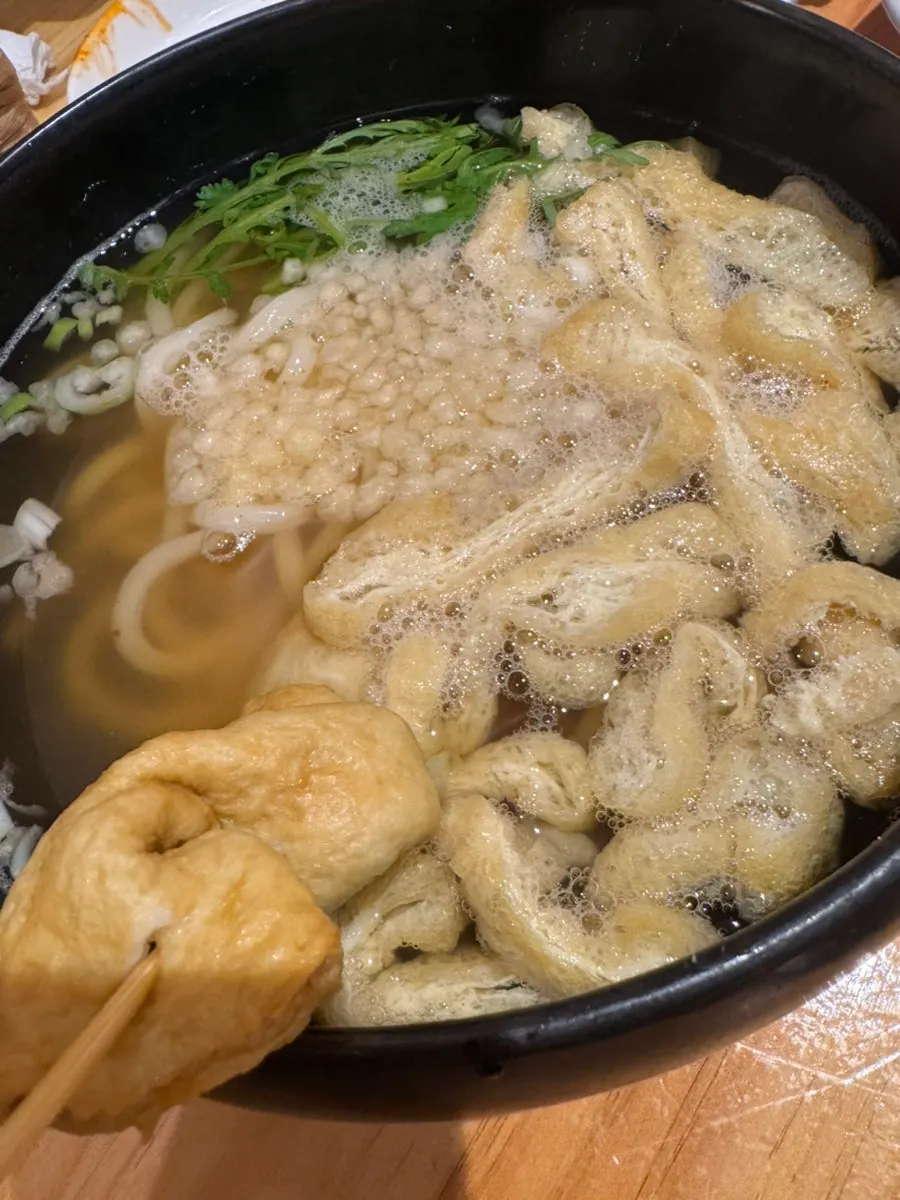 Bukseong-ro Udon topped with fried tofu skin and crown daisy greens