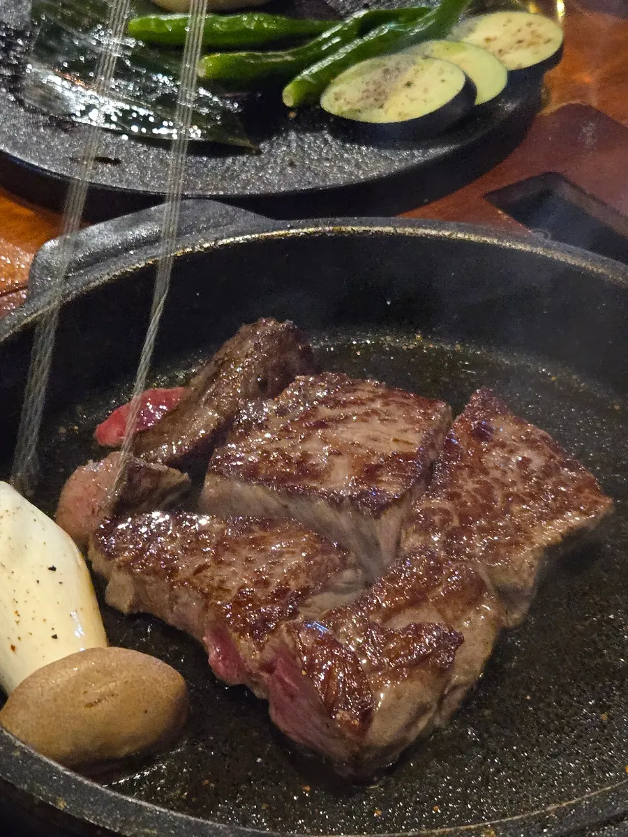 Staff grilling sirloin in a cast-iron pot